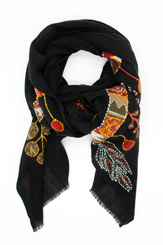 A styled black scarf with orange and brown nature patterns.