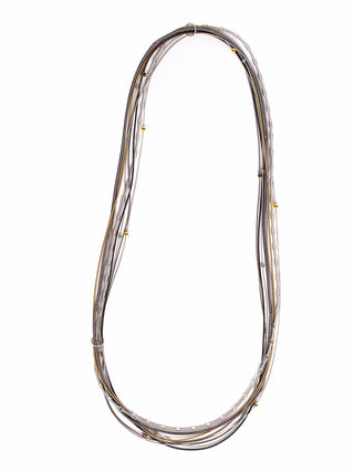 A long piano wire necklace decorated with small gold and silver toned beads and cubes.