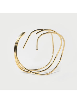 View of a brass waves bracelet through its opening.
