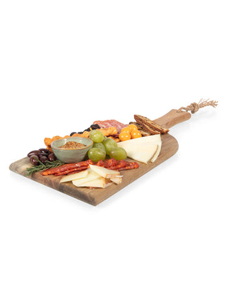 A wood plank at an angle, covered with olives, cheeses and meats.