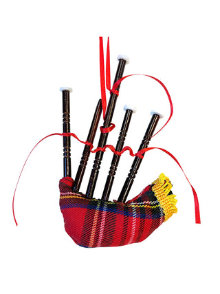 An ornament of a bagpipe with a red tartan fabric and gold tassels, with a red ribbon for hanging.