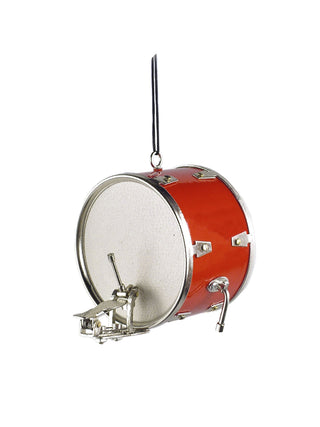 A red bass drum with a pedal on a silver cord.