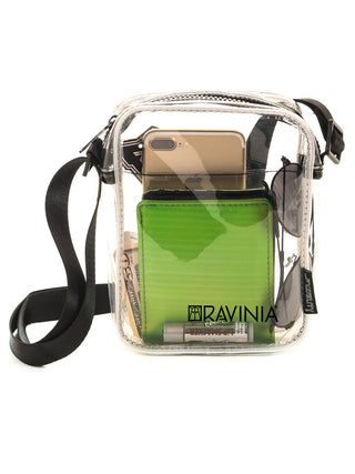 A transparent brick bag with a black strap and the Ravinia logo and name in black. Inside are a green wallet, money, sunglasses and cell phone.
