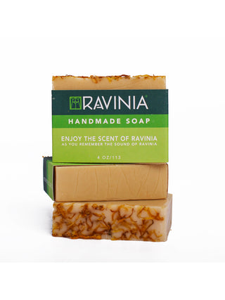 Three bars of beige soap stacked, with the top bar facing out and the words RAVINIA HANDMADE SOAP on the green label.