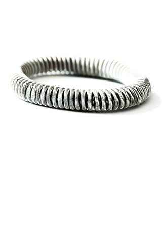 A bracelet made from coils of silver-toned wire.