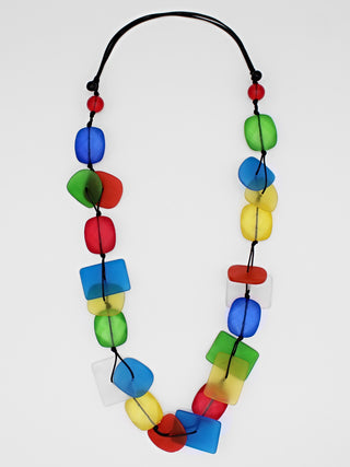 A colorful resin bead necklace, flat, with a variety of shapes and colors. 