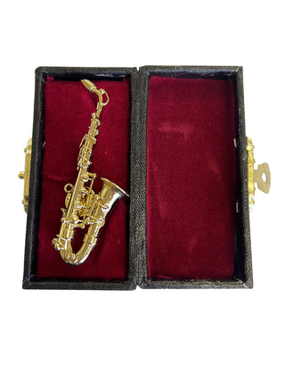 A lapel pin that looks like a gold saxophone, in a red, velvet-lined case.