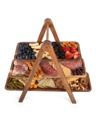 Side view of a three-tiered serving ladder, with each tray full of food.
