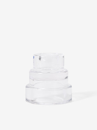 A clear, three-tiered glass candle holder.