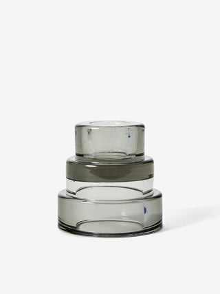A gray, three-tiered glass candle holder.