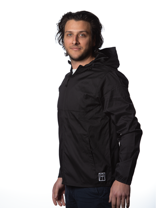 A young man in a black hooded windbreaker, with a white Ravinia logo near the hip.