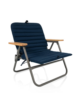 A navy padded foldable beach chair with wooden arm rests.