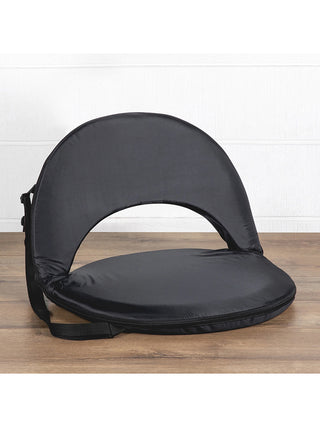 A black padded reclining seat with a shoulder strap, sitting on a wooden floor.