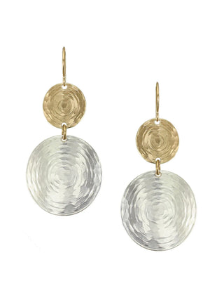 A pair of earrings made of a small brass hammered circle with a larger silver hammered circle hanging from it.