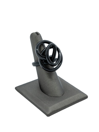 A black squiggle ring on a gray ring display.