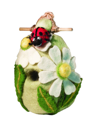 A felt birdhouse, decorated with leaves, flowers, and a large ladybug.