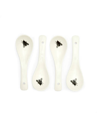 Four white ceramic spoons with a fly printed on the mouth of each one.
