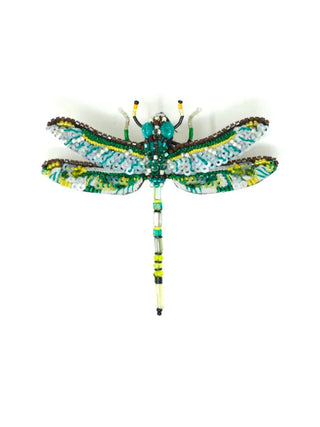 A brooch in a dragonfly design, green and aqua with yellow accents.