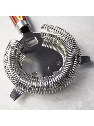 Close view of a stainless steel cocktail strainer.