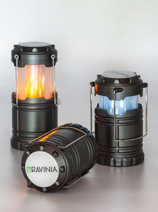 Three pop-up lanterns, the one on the left with a faux orange flame, the one in the center facing forward, with the Ravinia logo displayed, and the one on the right with a faux blue flame.