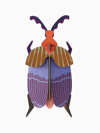 A purple, brown and orange cardboard queen beetle.