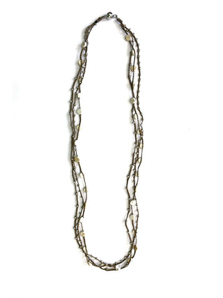 A long silk twine necklace adorned with silver-toned beads and white turquoise buttons.