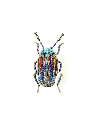An embroidered pin of a beetle, with a turquoise head and red and blue back with turquoise accents.