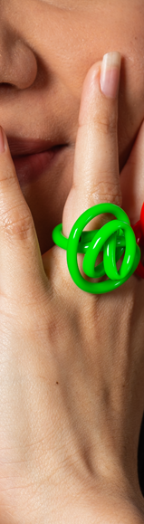A green squiggle ring on a finger.
