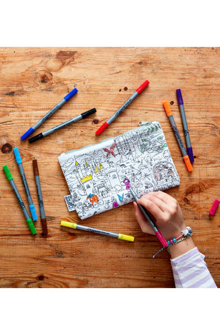 An overhead view of a girl's hand coloring the fairy tale pencil case.