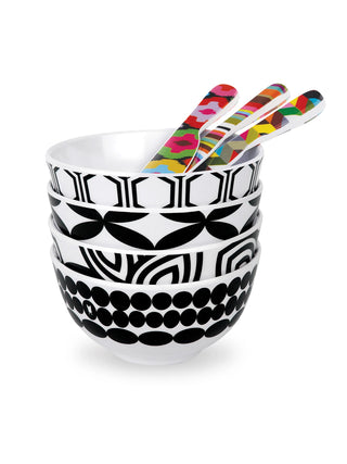 A stack of four bowls, each with a different black and white pattern, and four colorful spreaders in the top bow.