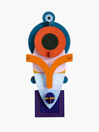 A colorful cardboard mask with an angular bottom and round top.