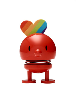 A red hoptimist figurine with a rainbow heart on its head.