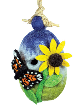 A felt birdhouse hanging from a rope, decorated with a bright yellow flower and monarch butterfly.