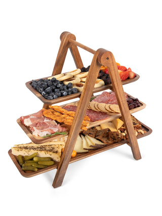 A three-tiered wooden serving ladder with each tray filled with food.