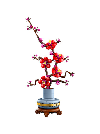 A LEGO plum blossom plant in red, in a silver vase and stand, on a white background.