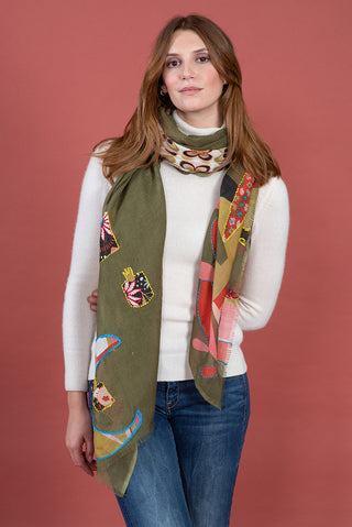 A woman wearing a scarf in khaki, green pink and red.