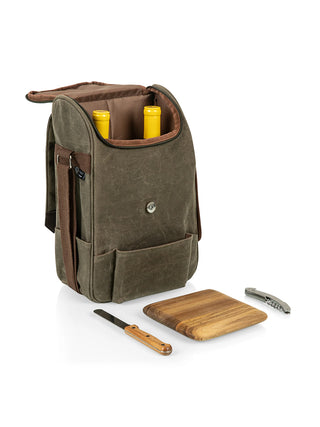 A canvas bag with two wine bottles inside, and a wooden cutting board, a cheese knife, and a corkscrew laid out in front of it.