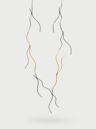 Strands from a necklace made of up brass and unfinished brass, which appears gray.