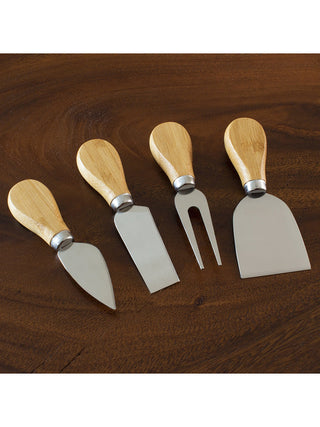 Four cheese tools with wooden handles on a wooden table.