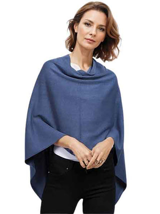 A woman wearing a blue poncho with black pants.