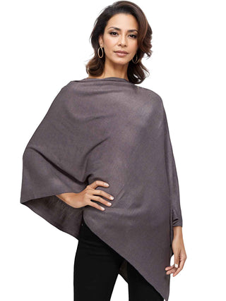 A woman wearing a dark grey poncho with black pants.