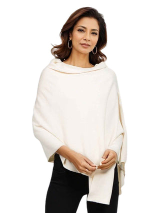 A model in an ivory-colored fabric poncho and black pants.