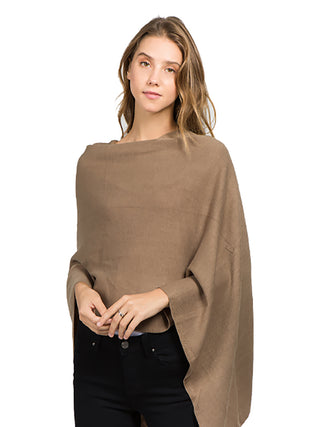 A model in a tan-colored fabric poncho and black pants.