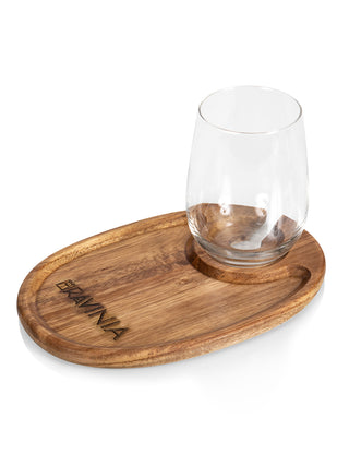 An oval wooden tray with a wine glass resting at one and and the word RAVINIA branded into the other.