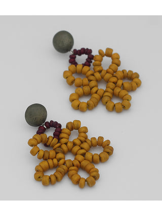 Angled view of Earrings in wine and mustard colored loops of beads.