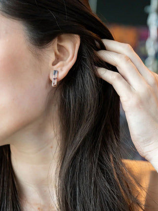 A model wearing the blonde tortoise bar stud earrings.