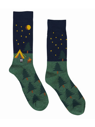 A pair of socks with images that evoke camping, like a tent, evergreen trees, campfire and starry night with moon.