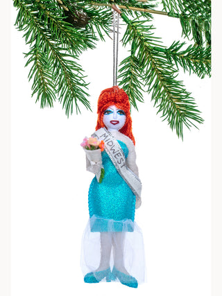 A felt ornament of Chappell Roan in a sparkly blue dress with a MIDWEST pageant sash and a bouquet of flowers.