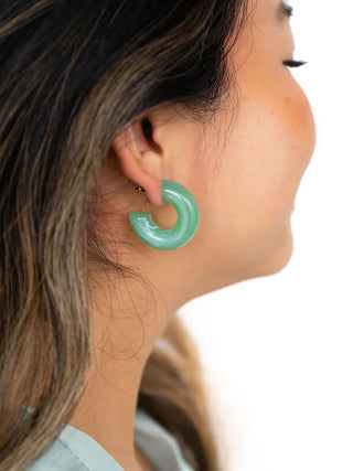 A model wearing the sage hoops.