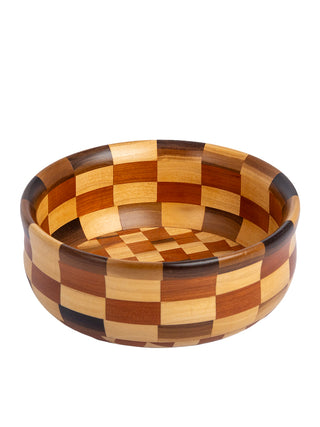 Overhead view of a wooden bowl with a checkerboard pattern in different shades of brown.